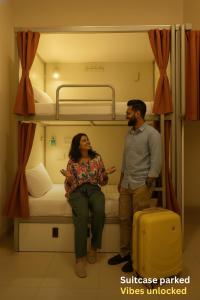 a man and a woman sitting on a bunk bed at Metro POD Hotel at New Delhi Metro & Railway Station in New Delhi +34 photos