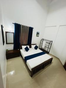a bedroom with two beds with blue pillows at Yala Mangora Inn in Tissamaharama +29 photos