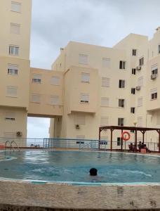 a person swimming in a pool in front of a building at Condominio atlantico ll in Praia