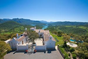 eine Luftansicht eines Hauses mit einem See im Hintergrund in der Unterkunft Cortijo Alcornocosa in El Bosque
