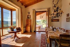 ein Esszimmer mit einem Tisch und einem großen Fenster in der Unterkunft Cortijo Alcornocosa in El Bosque