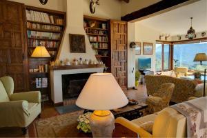 ein Wohnzimmer mit einem Kamin und einem Tisch mit einer Lampe in der Unterkunft Cortijo Alcornocosa in El Bosque