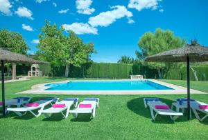 une piscine avec des chaises longues et un parasol dans l'établissement El Nogal, à Arriate