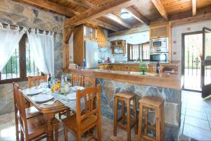 une cuisine avec une table, des chaises et un comptoir dans l'établissement El Nogal, à Arriate