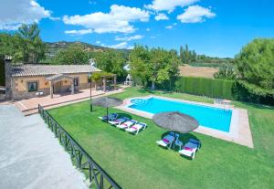 une vue aérienne d'une piscine avec chaises et parasols dans l'établissement El Nogal, à Arriate