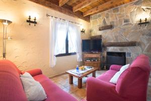- un salon avec un canapé rouge et un mur en pierre dans l'établissement El Nogal, à Arriate