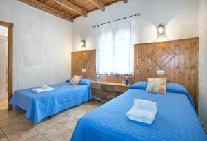 deux lits dans une chambre avec des draps bleus et un lavabo dans l'établissement El Nogal, à Arriate 19 autres photos