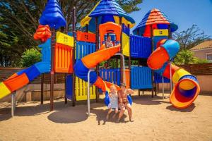 zwei kleine Kinder spielen auf einem Spielplatz in der Unterkunft Camping 4 étoiles - Parc aquatique - ccadfdf in Saint-Jean-de-Monts