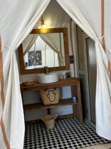 a bathroom with a sink and a mirror at Merzouga wonderful camp in Merzouga