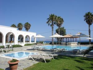 a large white swimming pool sitting in front of a house at Andromeda Hotel Apartments in Kos