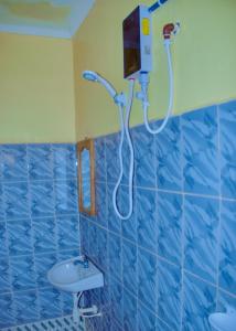 bagno piastrellato blu con doccia e lavandino di Biez Homestay a Karatu Altre 5 foto