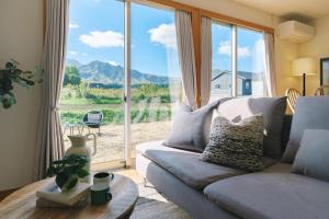 a living room with a couch and a large window at 阿蘇ビューテラス in Aso