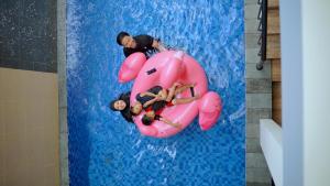 Un grupo de personas flotando en una balsa rosa en una piscina en Trasmambang, en Ngingas 9 fotos más