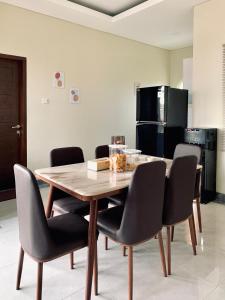 Una mesa de comedor con sillas y un refrigerador. en Trasmambang, en Ngingas
