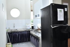 a kitchen with a black refrigerator and a sink at Trasmambang in Ngingas +7 photos