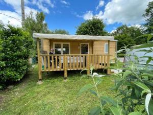 a man standing on the porch of a tiny house at Camping 3 étoiles - ccaaafd in Sorèze