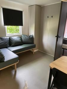 a living room with a couch and a window at Camping 3 étoiles - ccaaafd in Sorèze