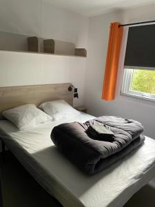 a bed with a black blanket on it in a bedroom at Camping 3 étoiles - ccaaafd in Sorèze +52 photos