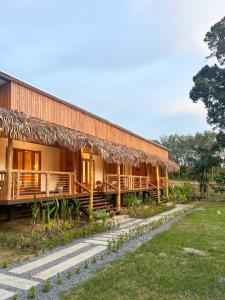 un grand bâtiment avec un toit en herbe dans l'établissement Painon Resort KohLanta, à Ko Bu Bu