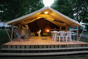 泰格拉Camping 4 étoiles - Piscine - eed0fi的木制甲板上配有桌椅的凉亭