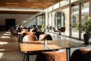 a restaurant with tables and chairs and windows at Jeroom Hostel in Jerusalem
