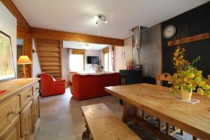 un salon avec une table et un canapé dans l'établissement Le Chalet Vert entre nature et animations, à La Bresse