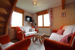 - un salon avec des chaises orange et un canapé dans l'établissement Le Chalet Vert entre nature et animations, à La Bresse