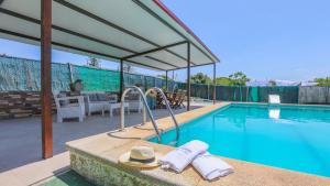 a swimming pool with a hat and towels next to it at Villa Josara by Ruralidays in Huelva