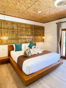une chambre avec un grand lit avec une tête de lit en bois dans l'établissement Painon Resort KohLanta, à Ko Bu Bu 63 autres photos
