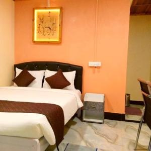 Pari's Homestay and Food Centre في Mawlynnong: غرفة نوم بسرير وصورة على الحائط