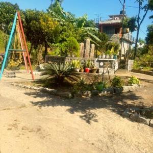 Pari's Homestay and Food Centre في Mawlynnong: ملعب مع مجموعة أرجوحة وبعض النباتات