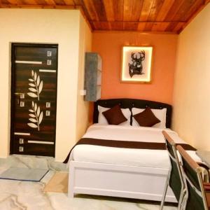 Pari's Homestay and Food Centre في Mawlynnong: غرفة نوم بسرير وباب