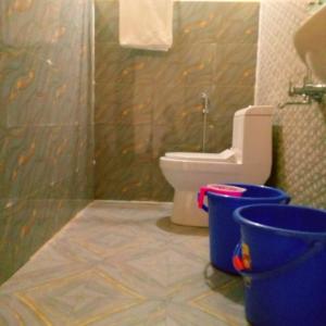 Pari's Homestay and Food Centre في Mawlynnong: حمام مع مرحاض ودليلين زرقاء