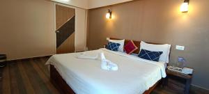 科代卡纳尔Raja Home Stay的卧室里有一张白色的大床，床上放着毛巾