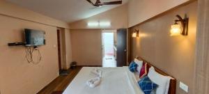 科代卡纳尔Raja Home Stay的一间卧室，墙上有一张床和一台电视