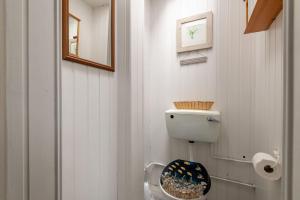 a white bathroom with a toilet and a mirror at Ampersand in Earlsferry +90 photos