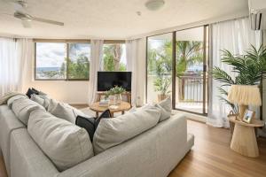 ゴールドコーストにあるPalms on Gold - Sun, Swims & Riverside Viewsのリビングルーム(大きなソファ、テレビ付)