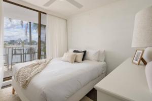 ゴールドコーストにあるPalms on Gold - Sun, Swims & Riverside Viewsの白いベッドルーム(ベッド1台、バルコニー付) +15枚の写真