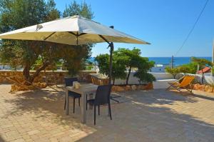 a table and chairs under an umbrella at B&B Lu Cantoru in Marina di Pescoluse