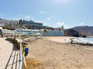 - une plage avec un hôtel et des personnes sur la plage dans l'établissement Mar de Luna, à Playa del Cura