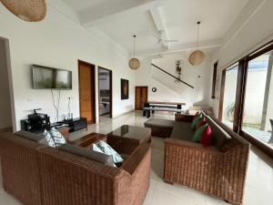 a living room with two couches and a tv at Villa Rob in Kerobokan