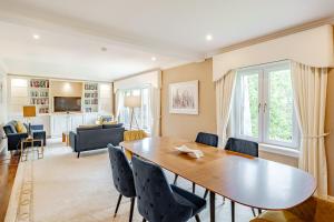 une salle à manger avec une table et des chaises et un salon dans l'établissement Spacious Gleneagles Apartment, 