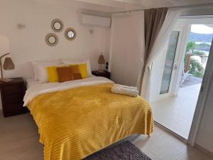 1 dormitorio con 1 cama con manta amarilla en Casa dulce - Camaruche, en Saint Barthelemy