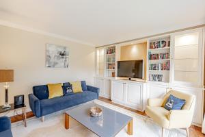 un salon avec un canapé bleu et une télévision dans l'établissement Spacious Gleneagles Apartment, 