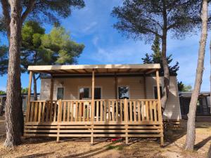 une maison avec une terrasse couverte et un toit dans l'établissement Bungalow proche mer CARRY LE ROUET, à Carry-le-Rouet