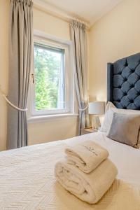 une chambre avec un lit avec deux serviettes dessus dans l'établissement Spacious Gleneagles Apartment, 