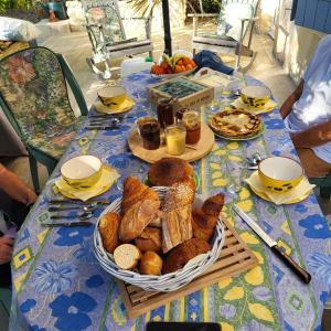 a table with a basket of bread and pastries on it at A la terrasse du val de vincelles in Nanteuil-lès-Meaux