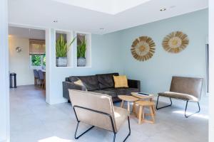 ein Wohnzimmer mit Couch und Stühlen in der Unterkunft Hello Zeeland - Vroonweg 34 in Oostkapelle