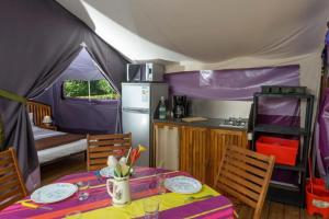 a tent with a table and a kitchen in it at Chalet 3 étoiles - Piscine - ccbbhfa in Clohars-Carnoët