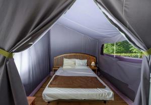 a bedroom with a bed in a tent at Chalet 3 étoiles - Piscine - ccbbhfa in Clohars-Carnoët